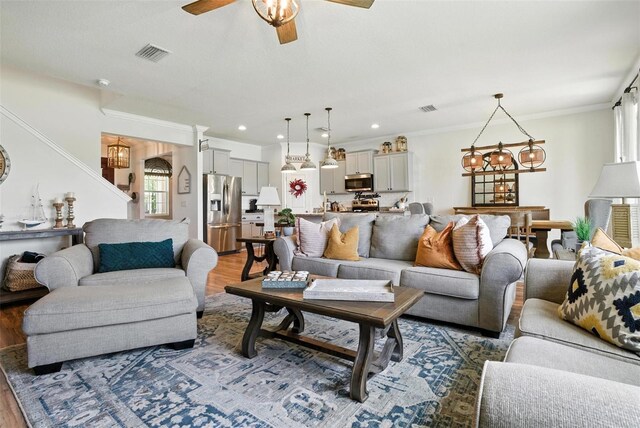 10603 Avian Forrest Dr, Riverview, FL 33578 - living room with wood finished floors, a ceiling fan, ornamental molding, recessed lighting, and a chandelier