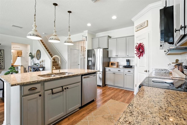 10603 Avian Forrest Dr, Riverview, FL 33578 - kitchen with stainless steel appliances, gray cabinets, light wood-style flooring, a center island with sink, and crown molding