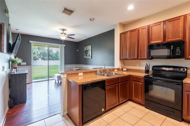 8814 Red Beechwood Ct, Riverview, FL 33578 - kitchen featuring black appliances, a peninsula, brown cabinetry, a ceiling fan, and recessed lighting