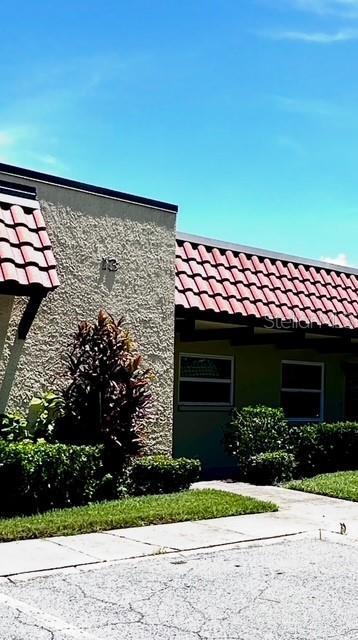 1701 Pinehurst Rd Unit 13C, Dunedin, FL 34698 - view of property exterior with a tile roof and stucco siding