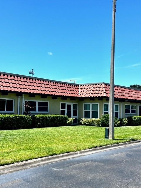 1701 Pinehurst Rd Unit 13C, Dunedin, FL 34698 - view of front of property with stucco siding, a tile roof, and a front lawn