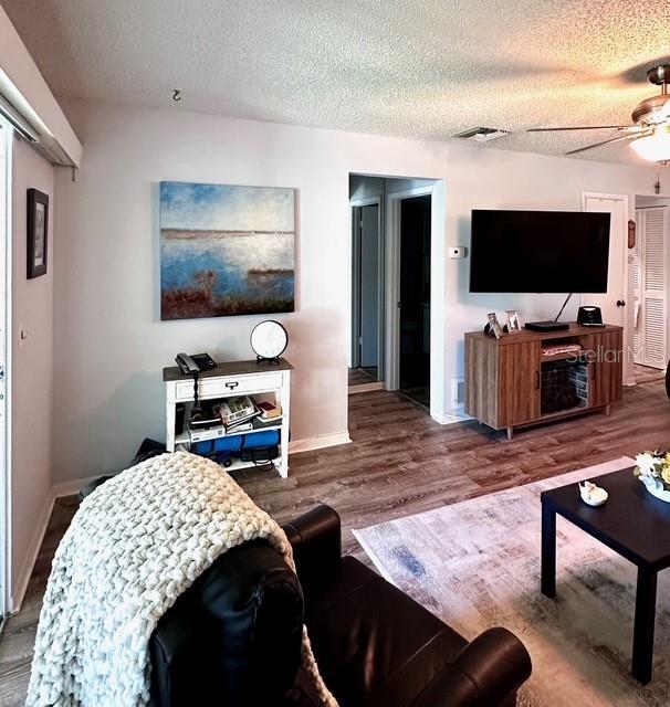 1701 Pinehurst Rd Unit 13C, Dunedin, FL 34698 - living room with a textured ceiling and wood finished floors