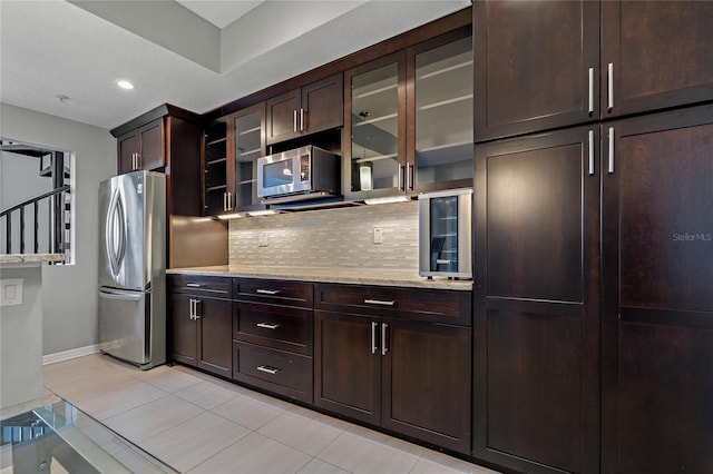 501 Knights Run Ave Unit 1317, Tampa, FL 33602 - kitchen featuring appliances with stainless steel finishes, decorative backsplash, dark brown cabinetry, light tile patterned floors, and recessed lighting