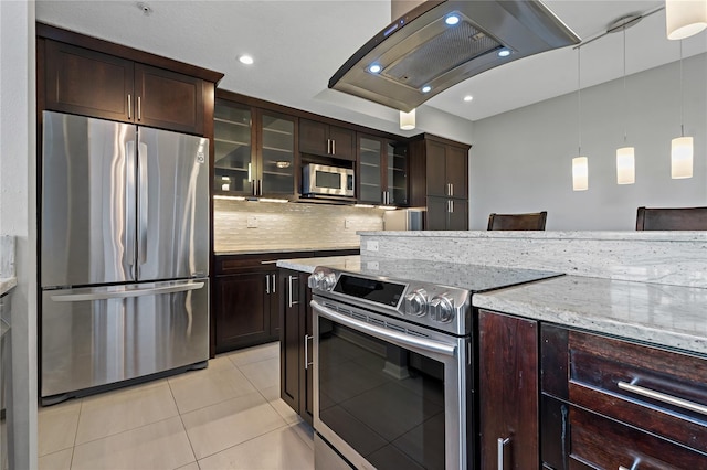 501 Knights Run Ave Unit 1317, Tampa, FL 33602 - kitchen with appliances with stainless steel finishes, light tile patterned floors, light stone counters, dark brown cabinets, and decorative backsplash