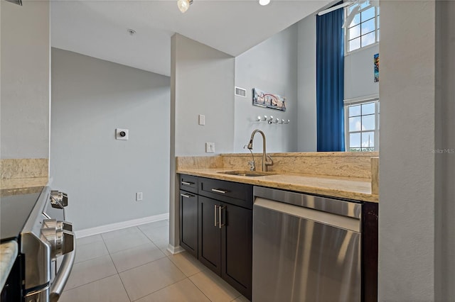 501 Knights Run Ave Unit 1317, Tampa, FL 33602 - kitchen with appliances with stainless steel finishes, light stone countertops, and light tile patterned flooring