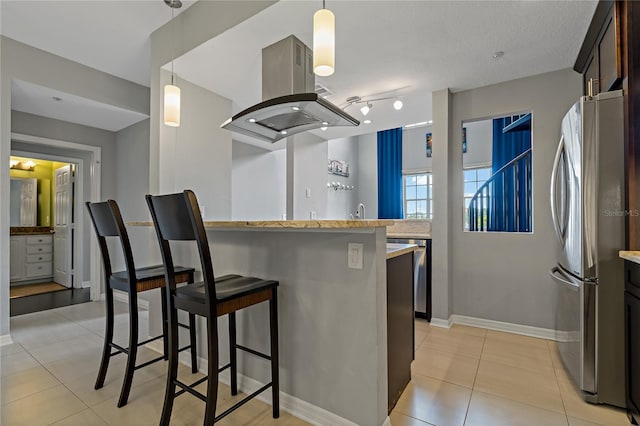 501 Knights Run Ave Unit 1317, Tampa, FL 33602 - kitchen with freestanding refrigerator, a breakfast bar, island exhaust hood, light tile patterned flooring, and dark brown cabinetry