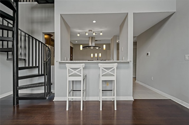 501 Knights Run Ave Unit 1317, Tampa, FL 33602 - kitchen with range hood, wood finished floors, and a breakfast bar area