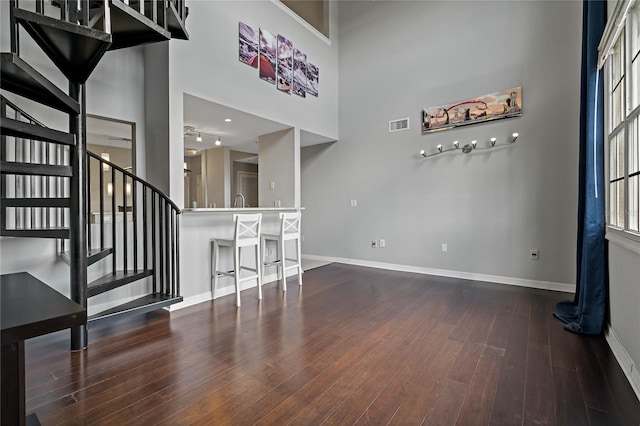 501 Knights Run Ave Unit 1317, Tampa, FL 33602 - unfurnished living room featuring wood finished floors, stairs, and a towering ceiling