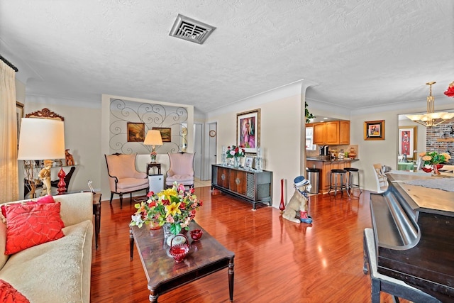 13565 86th Ave, Seminole, FL 33776 - living area with a chandelier, a textured ceiling, wood finished floors, and crown molding