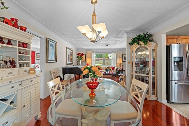 13565 86th Ave, Seminole, FL 33776 - dining area featuring light wood finished floors, a chandelier, and a textured ceiling