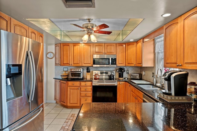 13565 86th Ave, Seminole, FL 33776 - kitchen with appliances with stainless steel finishes, a ceiling fan, light tile patterned floors, decorative backsplash, and brown cabinets