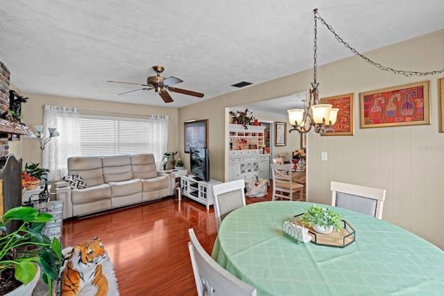 13565 86th Ave, Seminole, FL 33776 - dining space featuring wood finished floors, a chandelier, ceiling fan, and a textured ceiling
