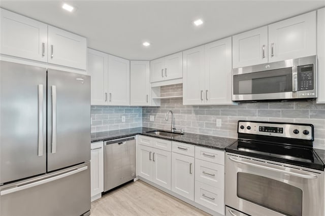 51 Island Way Unit 411, Clearwater Beach, FL 33767 - kitchen with appliances with stainless steel finishes, dark stone counters, white cabinetry, and recessed lighting