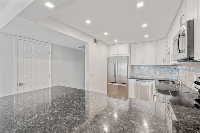 51 Island Way Unit 411, Clearwater Beach, FL 33767 - kitchen featuring appliances with stainless steel finishes, backsplash, white cabinets, dark stone counters, and recessed lighting