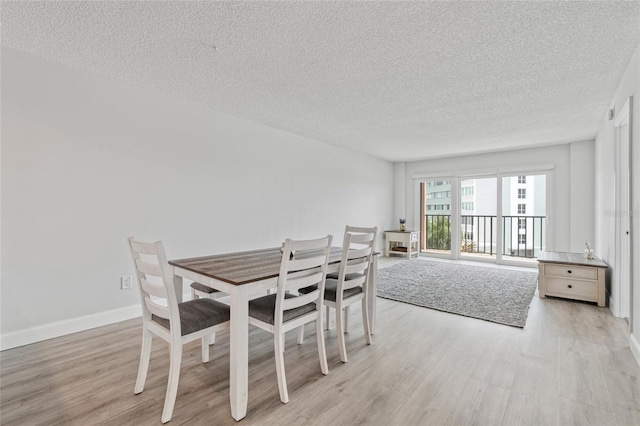 51 Island Way Unit 411, Clearwater Beach, FL 33767 - dining room with light wood-style flooring and a textured ceiling