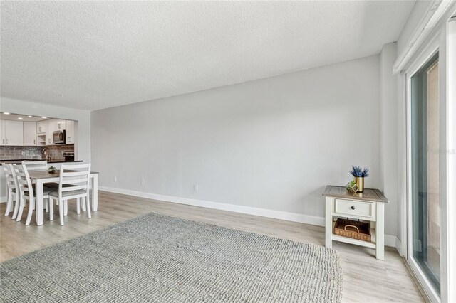 51 Island Way Unit 411, Clearwater Beach, FL 33767 - dining space with light wood-style floors, healthy amount of natural light, and a textured ceiling