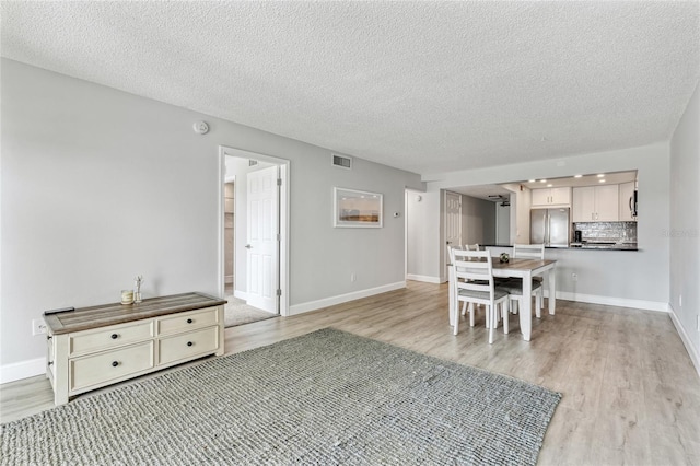 51 Island Way Unit 411, Clearwater Beach, FL 33767 - dining space featuring light wood-style floors and a textured ceiling