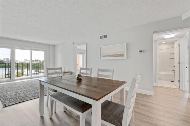 51 Island Way Unit 411, Clearwater Beach, FL 33767 - dining room with light wood finished floors and a textured ceiling
