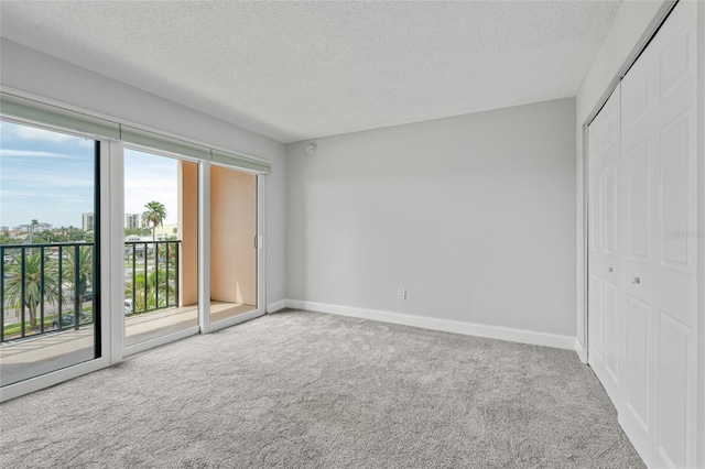 51 Island Way Unit 411, Clearwater Beach, FL 33767 - unfurnished bedroom featuring access to exterior, carpet flooring, a closet, and a textured ceiling