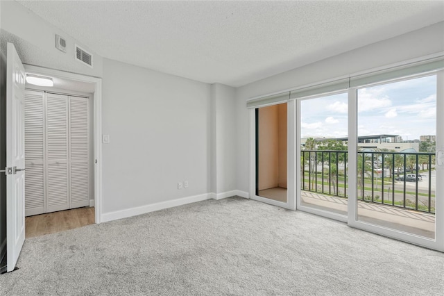 51 Island Way Unit 411, Clearwater Beach, FL 33767 - unfurnished bedroom featuring carpet, access to exterior, and a textured ceiling