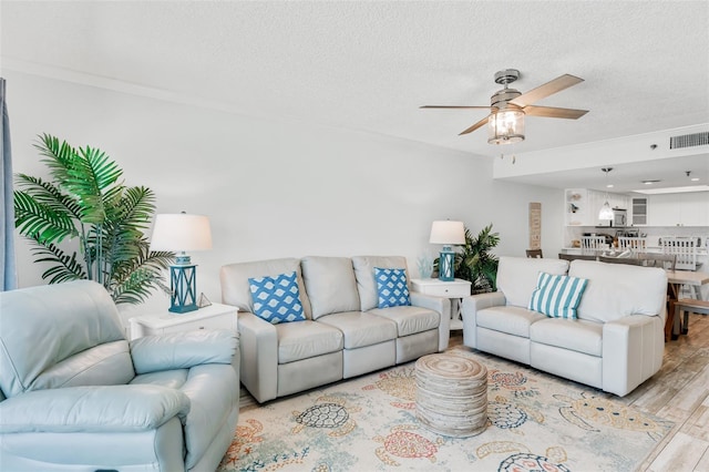 18500 Gulf Blvd Unit 503, Indian Shores, FL 33785 - living area with light wood finished floors, ceiling fan, a textured ceiling, and crown molding