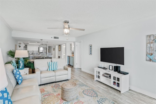 18500 Gulf Blvd Unit 503, Indian Shores, FL 33785 - living area with wood finished floors, a ceiling fan, a textured ceiling, and ornamental molding