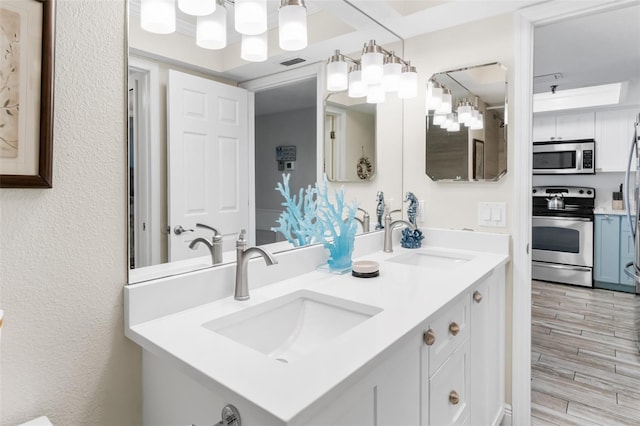 18500 Gulf Blvd Unit 503, Indian Shores, FL 33785 - bathroom featuring double vanity, a textured wall, a chandelier, and wood finished floors