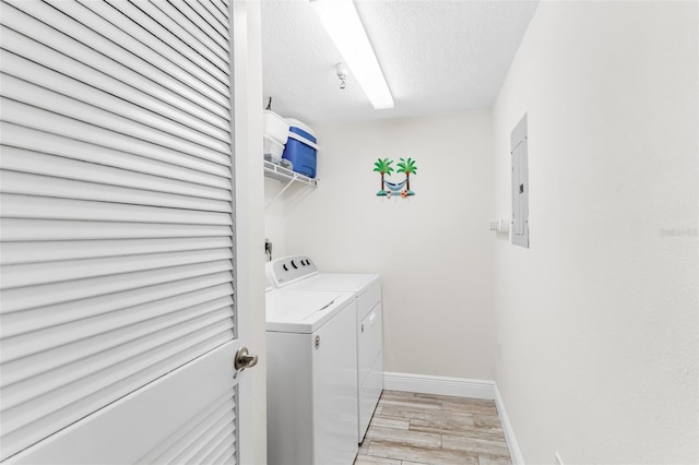 18500 Gulf Blvd Unit 503, Indian Shores, FL 33785 - laundry room with light wood-style floors, washing machine and clothes dryer, a textured ceiling, and electric panel