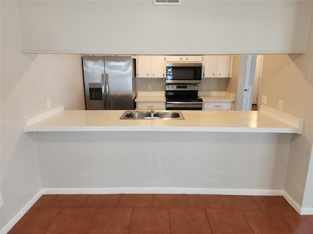 4009 Forecast Dr, Brandon, FL 33511 - kitchen with stainless steel appliances, a peninsula, tile patterned floors, light countertops, and white cabinetry