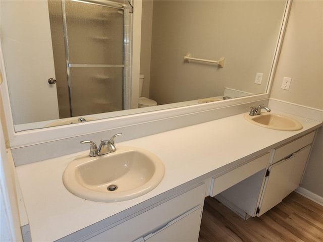 4009 Forecast Dr, Brandon, FL 33511 - bathroom with double vanity, a stall shower, and wood finished floors