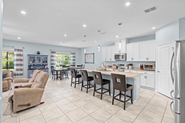 10618 Daybreak Gln, Parrish, FL 34219 - kitchen with stainless steel appliances, light tile patterned floors, open floor plan, recessed lighting, and a breakfast bar