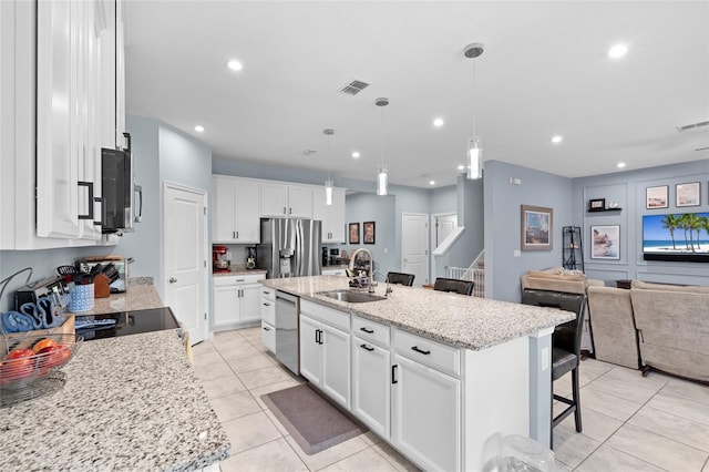 10618 Daybreak Gln, Parrish, FL 34219 - kitchen featuring stainless steel appliances, a breakfast bar area, recessed lighting, light tile patterned floors, and a kitchen island with sink