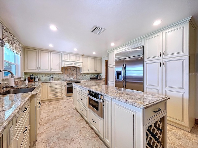 11141 Carla Dr, Largo, FL 33774 - kitchen featuring stainless steel appliances, a center island, light stone countertops, recessed lighting, and backsplash