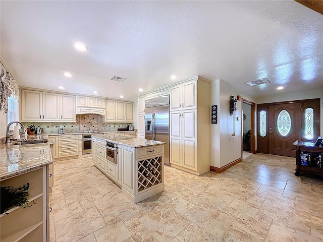 11141 Carla Dr, Largo, FL 33774 - kitchen with appliances with stainless steel finishes, stone tile flooring, light stone countertops, premium range hood, and recessed lighting