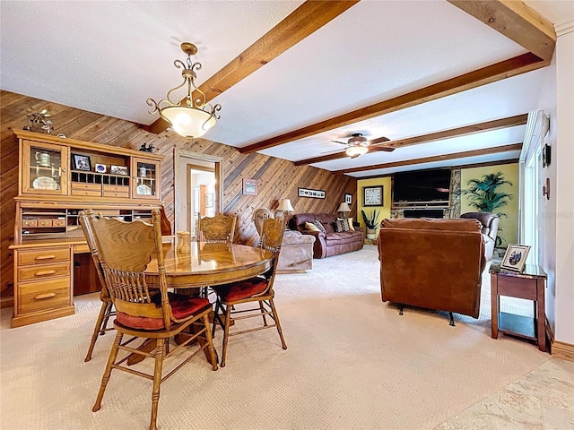 11141 Carla Dr, Largo, FL 33774 - dining space with wood walls, light colored carpet, beamed ceiling, and a ceiling fan