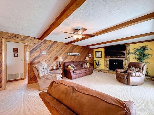11141 Carla Dr, Largo, FL 33774 - carpeted living room featuring beamed ceiling, wood walls, a ceiling fan, a fireplace, and a textured ceiling