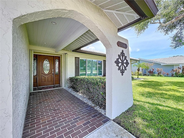 11141 Carla Dr, Largo, FL 33774 - view of exterior entry with stucco siding and a yard