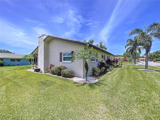 11141 Carla Dr, Largo, FL 33774 - view of home's exterior with stucco siding, a lawn, and a chimney