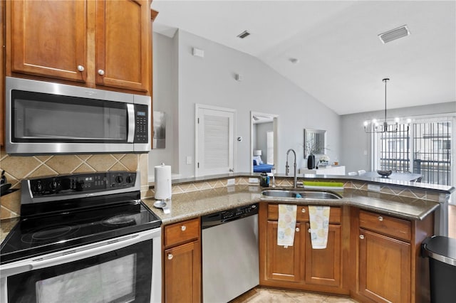 6734 Breezy Palm Dr, Riverview, FL 33578 - kitchen featuring stainless steel appliances, lofted ceiling, brown cabinets, decorative backsplash, and stone counters