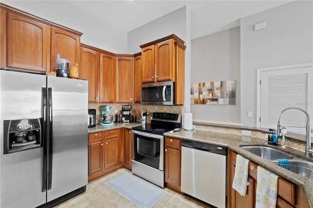 6734 Breezy Palm Dr, Riverview, FL 33578 - kitchen featuring appliances with stainless steel finishes, tasteful backsplash, light stone counters, and brown cabinets