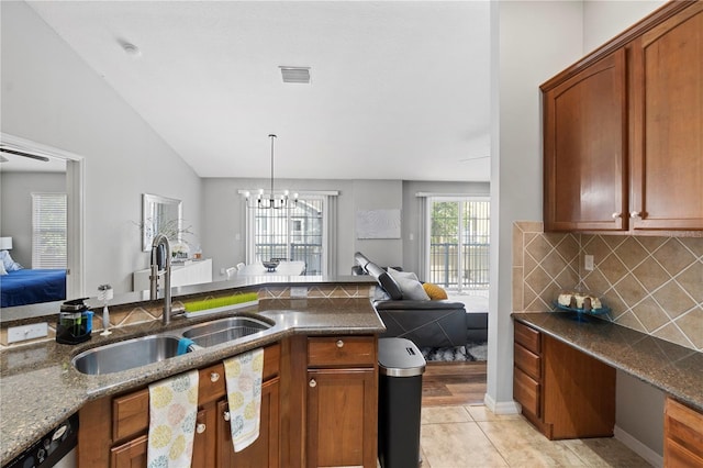 6734 Breezy Palm Dr, Riverview, FL 33578 - kitchen with open floor plan, a chandelier, stainless steel dishwasher, decorative backsplash, and dark stone countertops