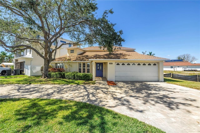 17601 Sterling Ter, Redington Shores, FL 33708 - view of front of house with decorative driveway, stucco siding, a garage, and a front yard