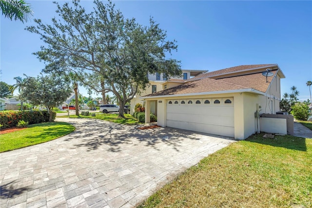 17601 Sterling Ter, Redington Shores, FL 33708 - view of front facade with decorative driveway, a garage, stucco siding, a front lawn, and roof with shingles