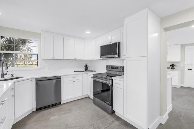 17601 Sterling Ter, Redington Shores, FL 33708 - kitchen with appliances with stainless steel finishes, white cabinets, light countertops, and recessed lighting