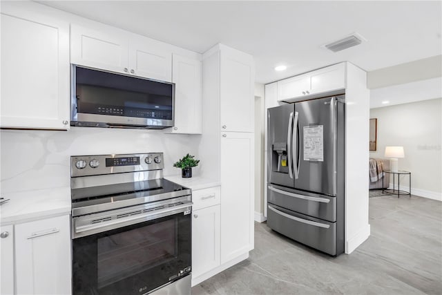17601 Sterling Ter, Redington Shores, FL 33708 - kitchen featuring appliances with stainless steel finishes, white cabinetry, light stone counters, and recessed lighting