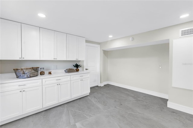 17601 Sterling Ter, Redington Shores, FL 33708 - kitchen featuring light countertops, white cabinets, and recessed lighting