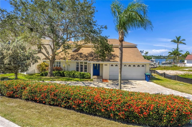 17601 Sterling Ter, Redington Shores, FL 33708 - view of front of property featuring an attached garage, concrete driveway, stucco siding, and roof with shingles