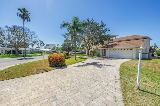 17601 Sterling Ter, Redington Shores, FL 33708 - view of front of home with decorative driveway, an attached garage, and a front lawn