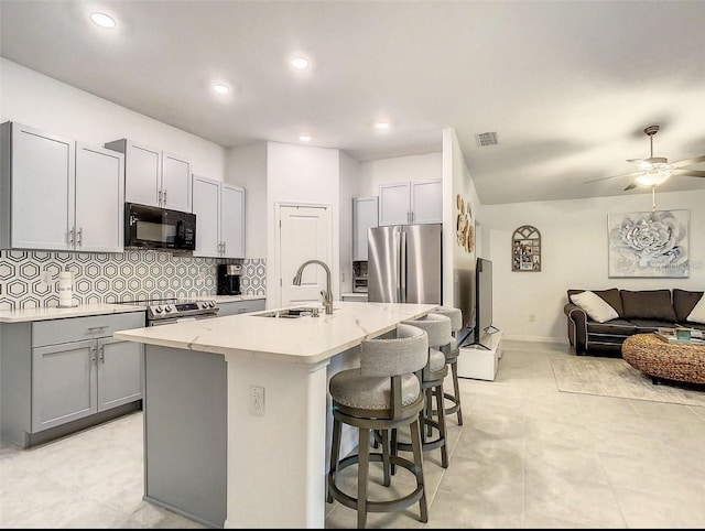 4282 Salt Springs Ln, Lakeland, FL 33811 - kitchen with stainless steel appliances, gray cabinets, a kitchen island with sink, tasteful backsplash, and recessed lighting