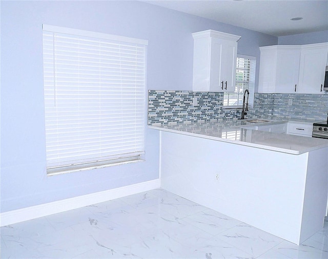 1302 Highview Rd, Brandon, FL 33510 - kitchen featuring white cabinetry, light countertops, tasteful backsplash, and light marble finish flooring
